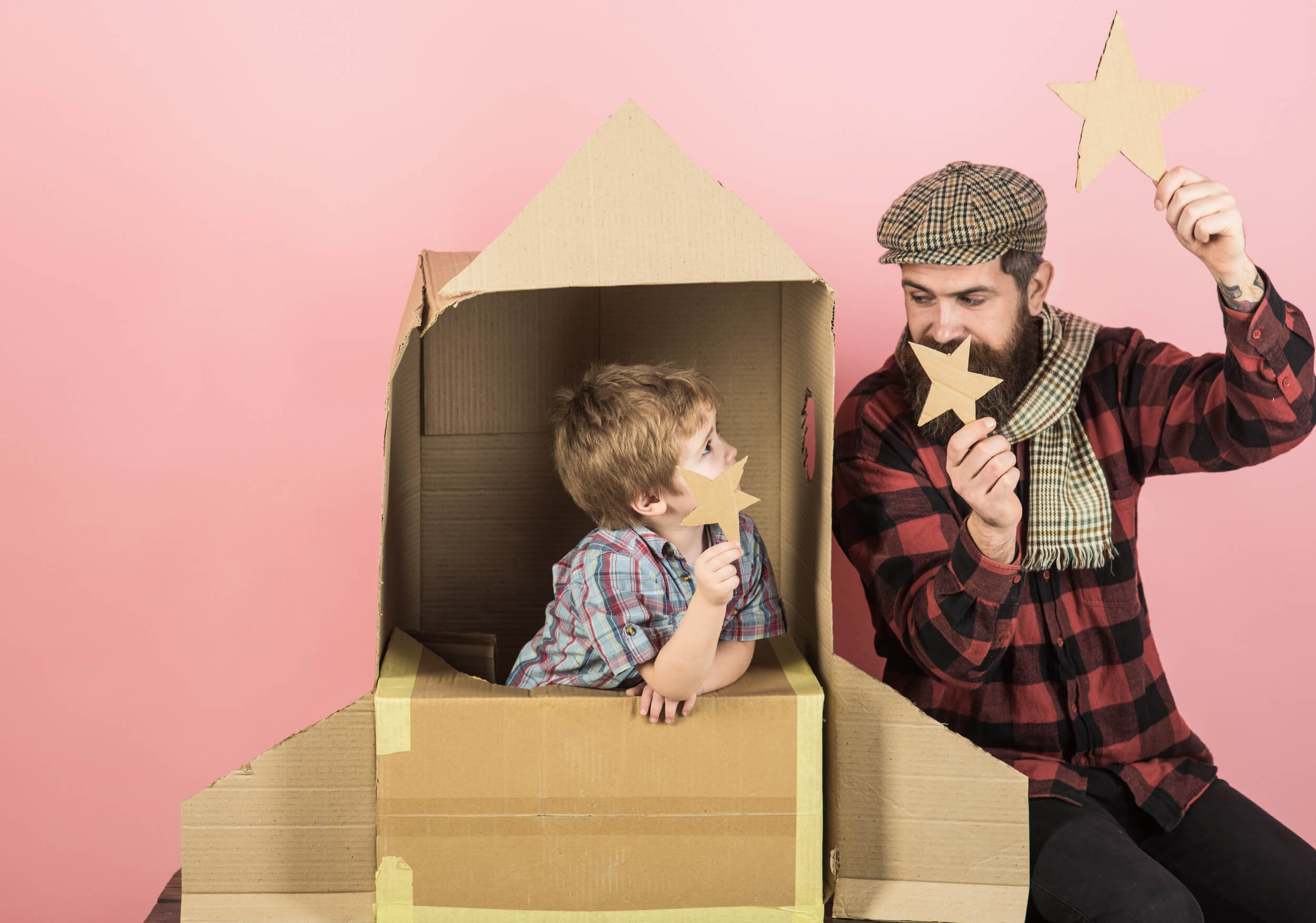 homme et enfant avec une fusée en carton