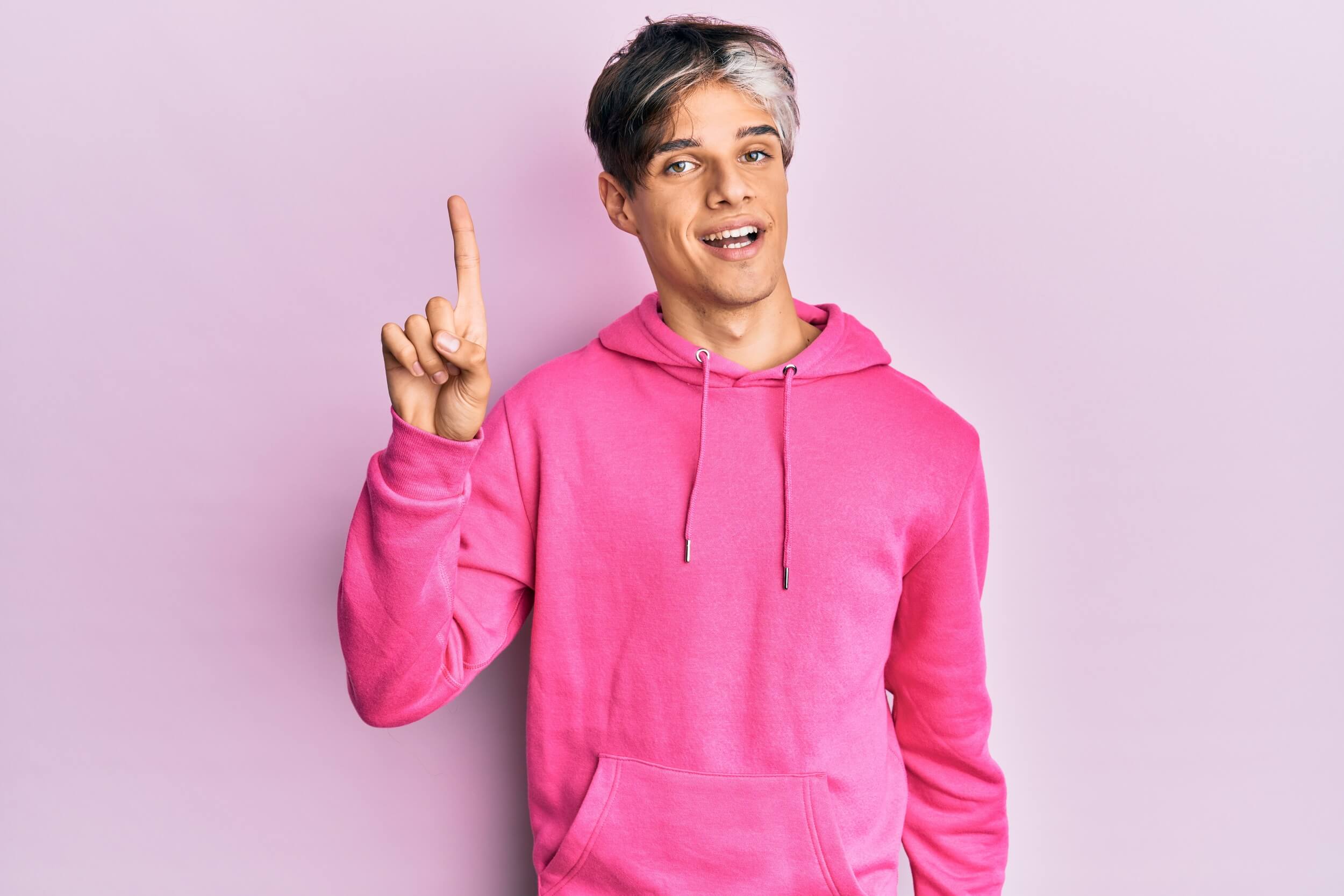 homme en rose le doigt levé