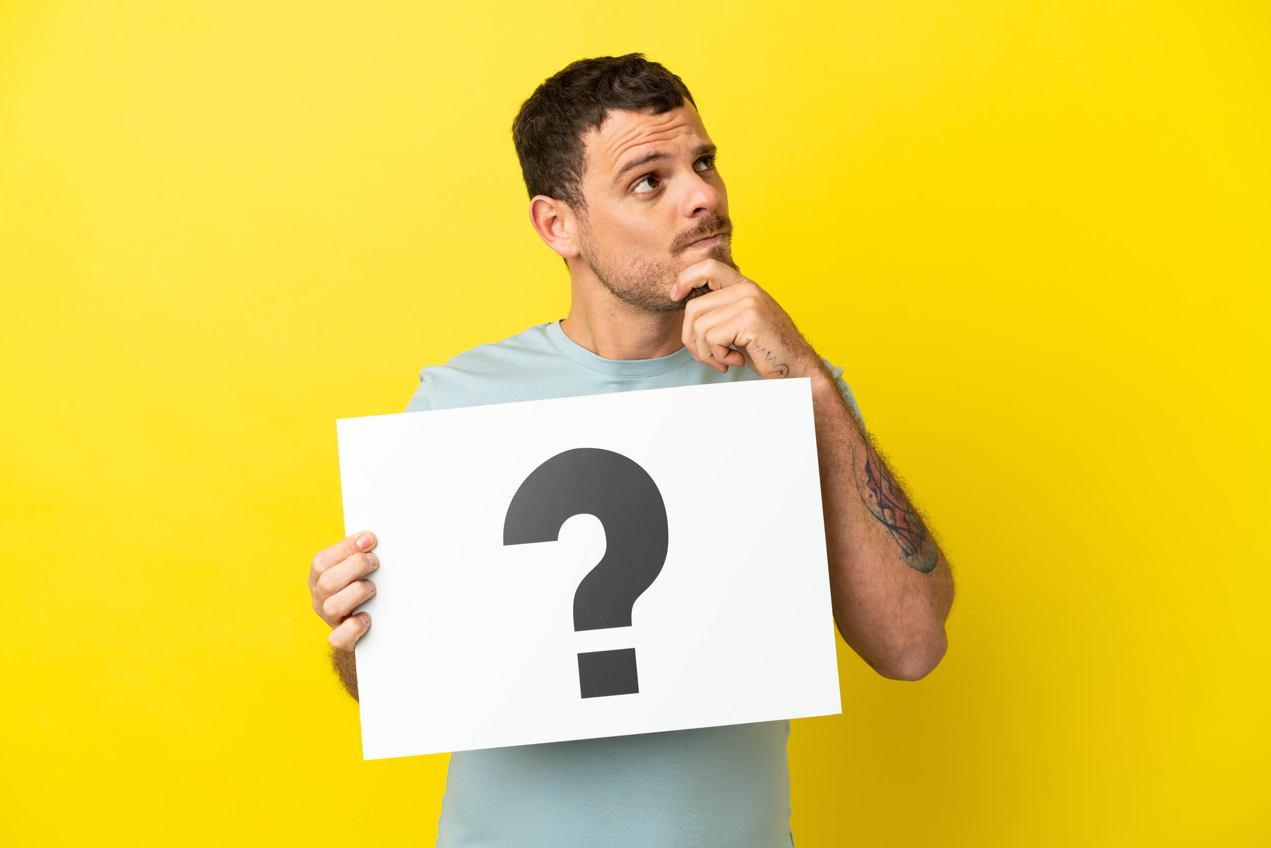 homme tient une pancarte avec un point d'interrogation