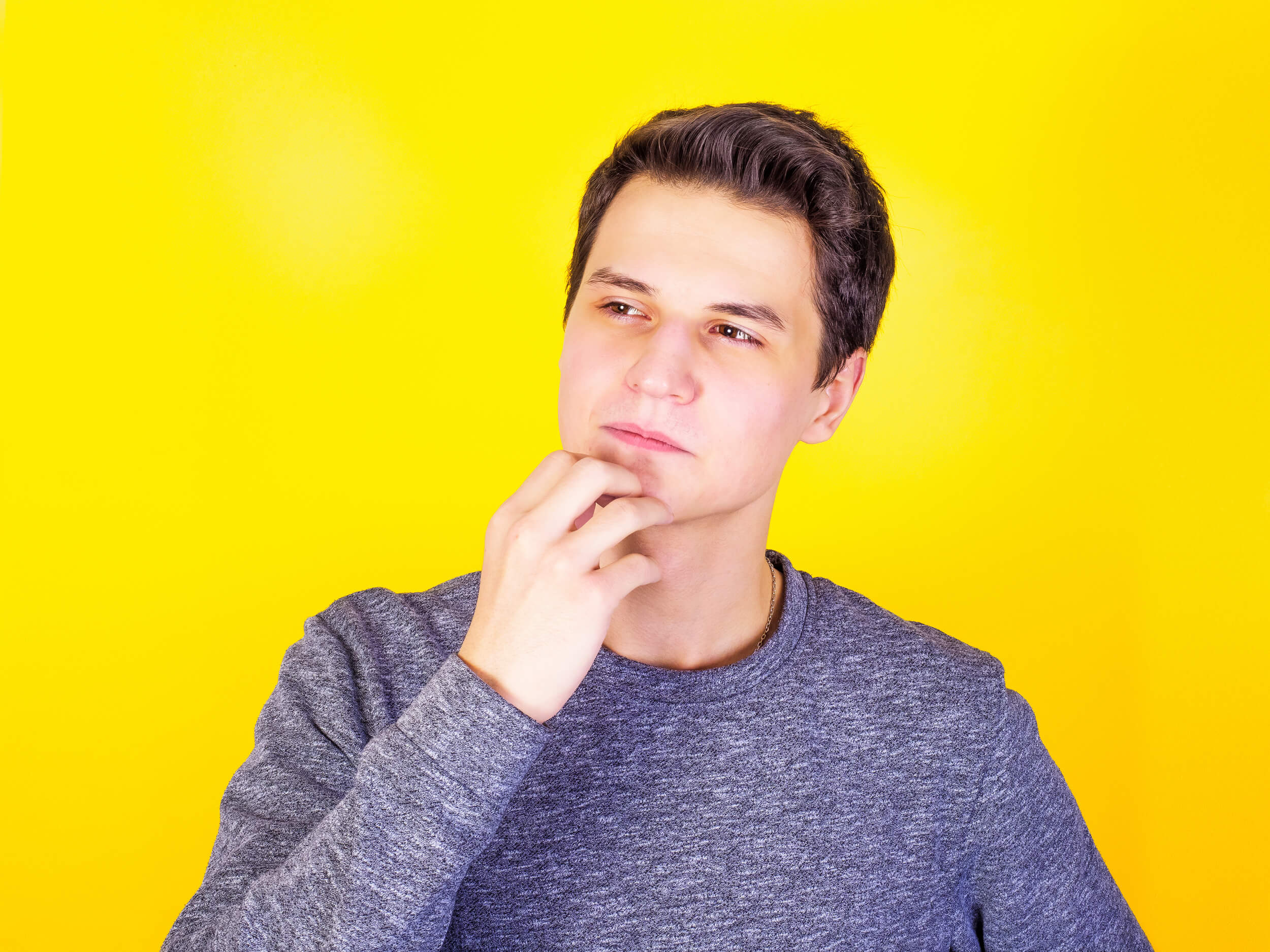 jeune homme se gratte le menton