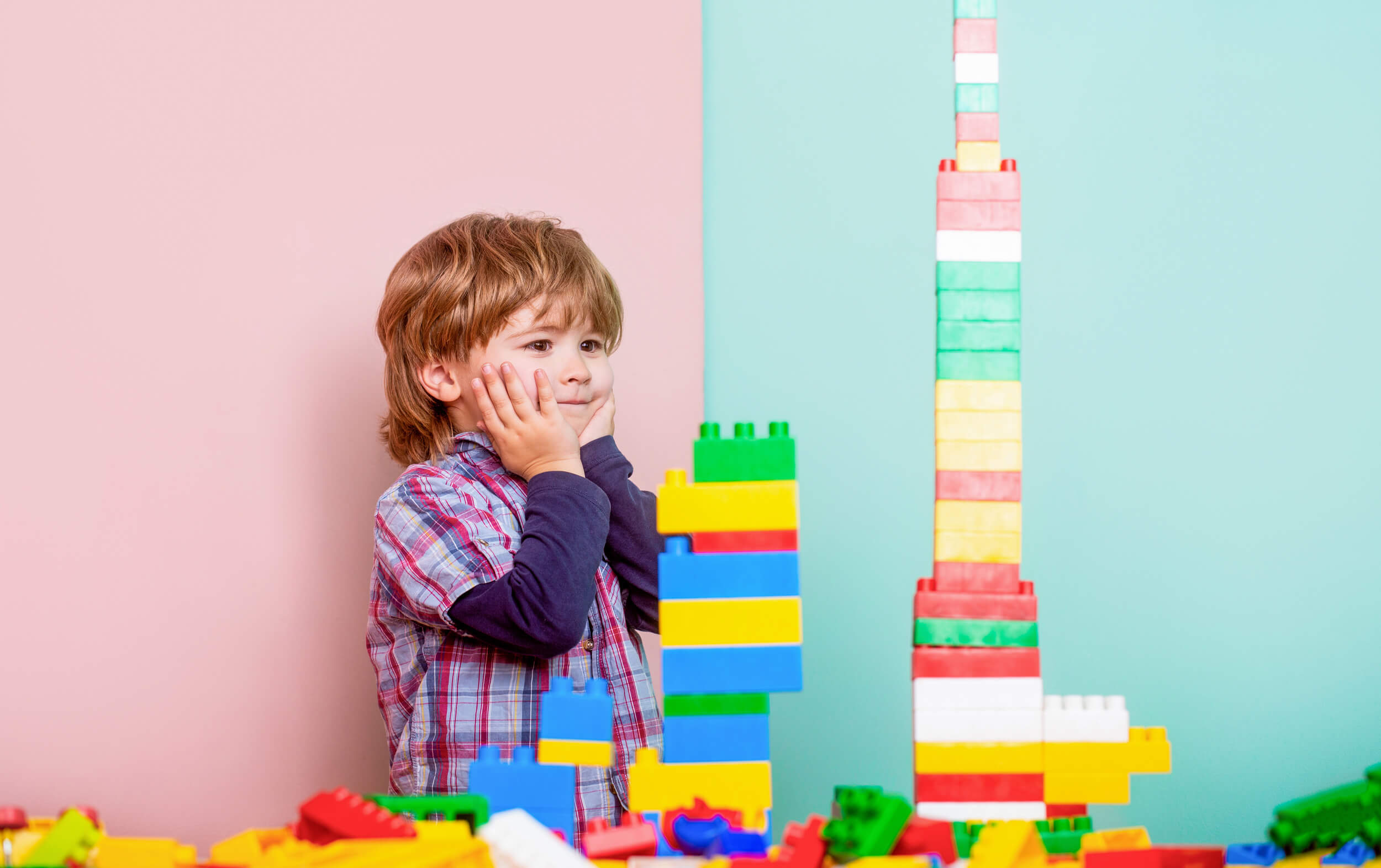 enfant qui construit une tour avec des legos
