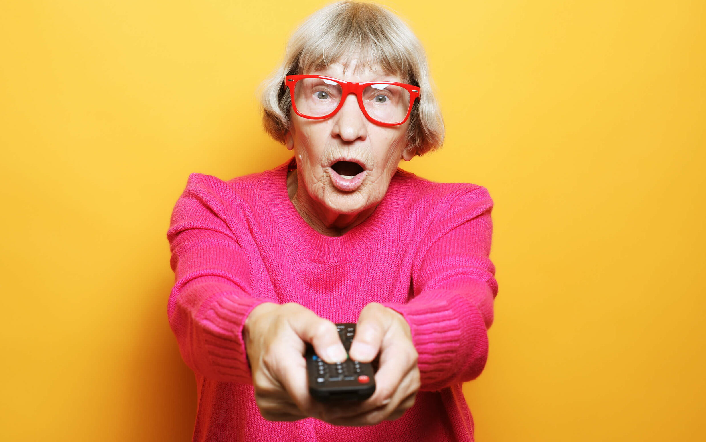 vieille dame avec une télécommande qui zappe