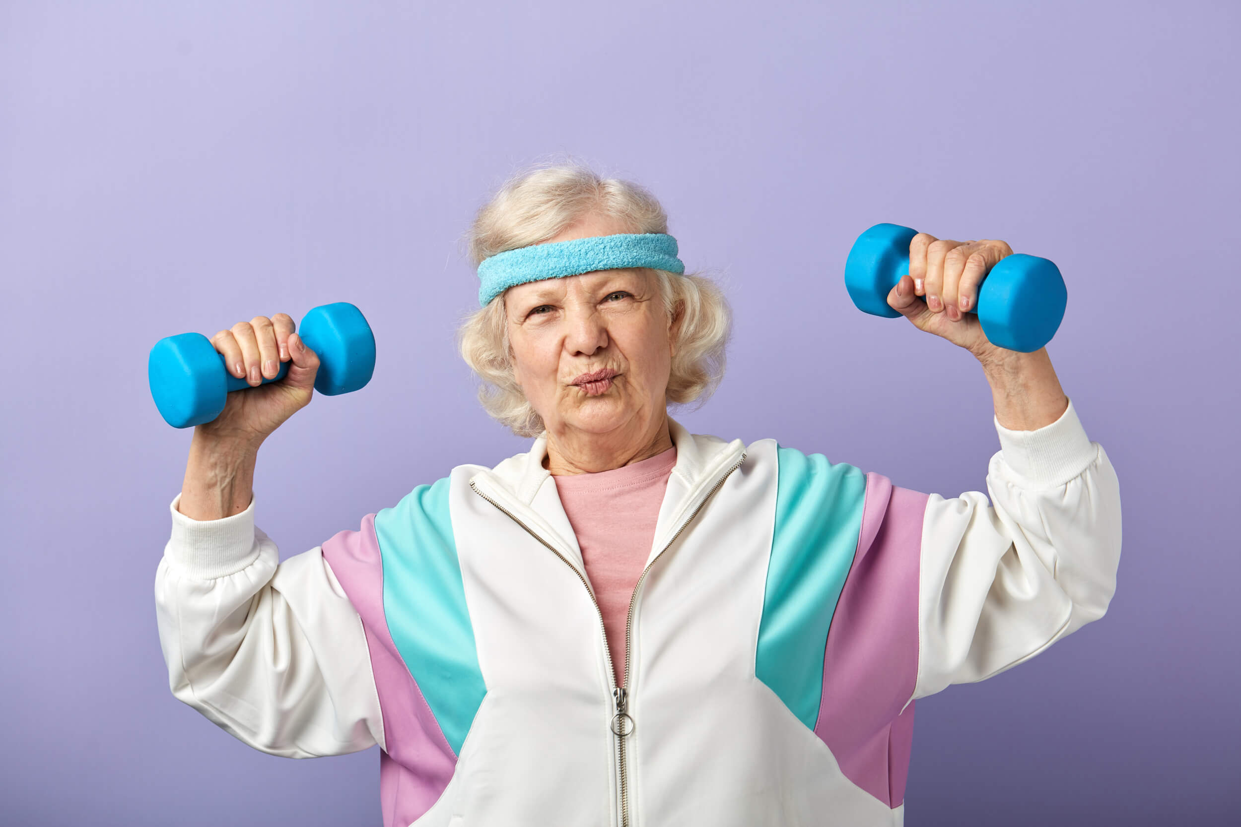 vieille dame en jogging avec des altères