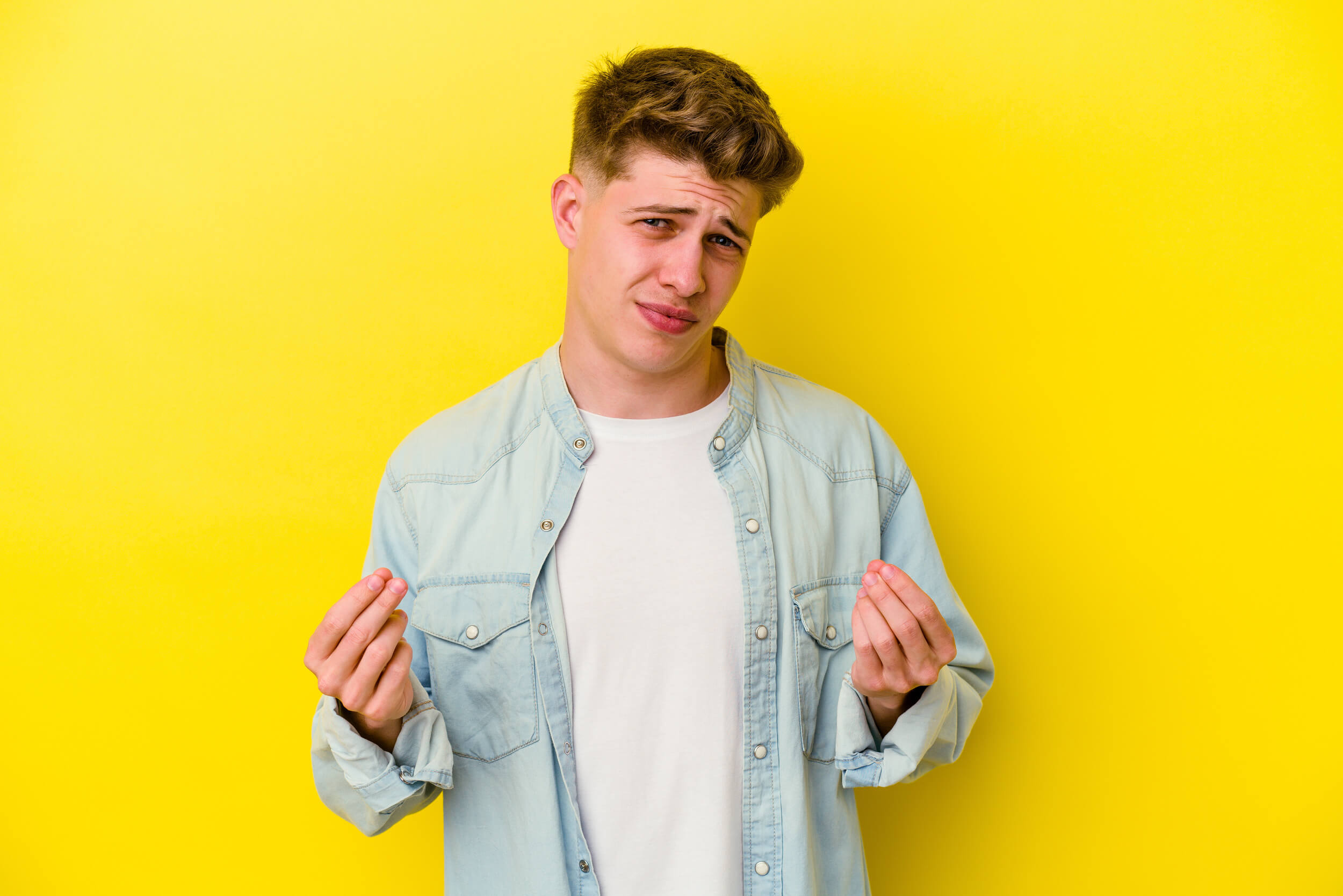 homme fait signe "argent" avec ses mains