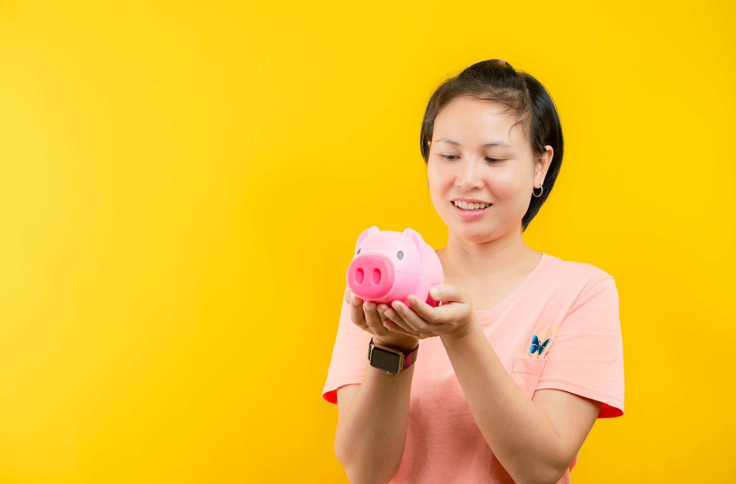 femme avec une tirelire cochon entre ses mains