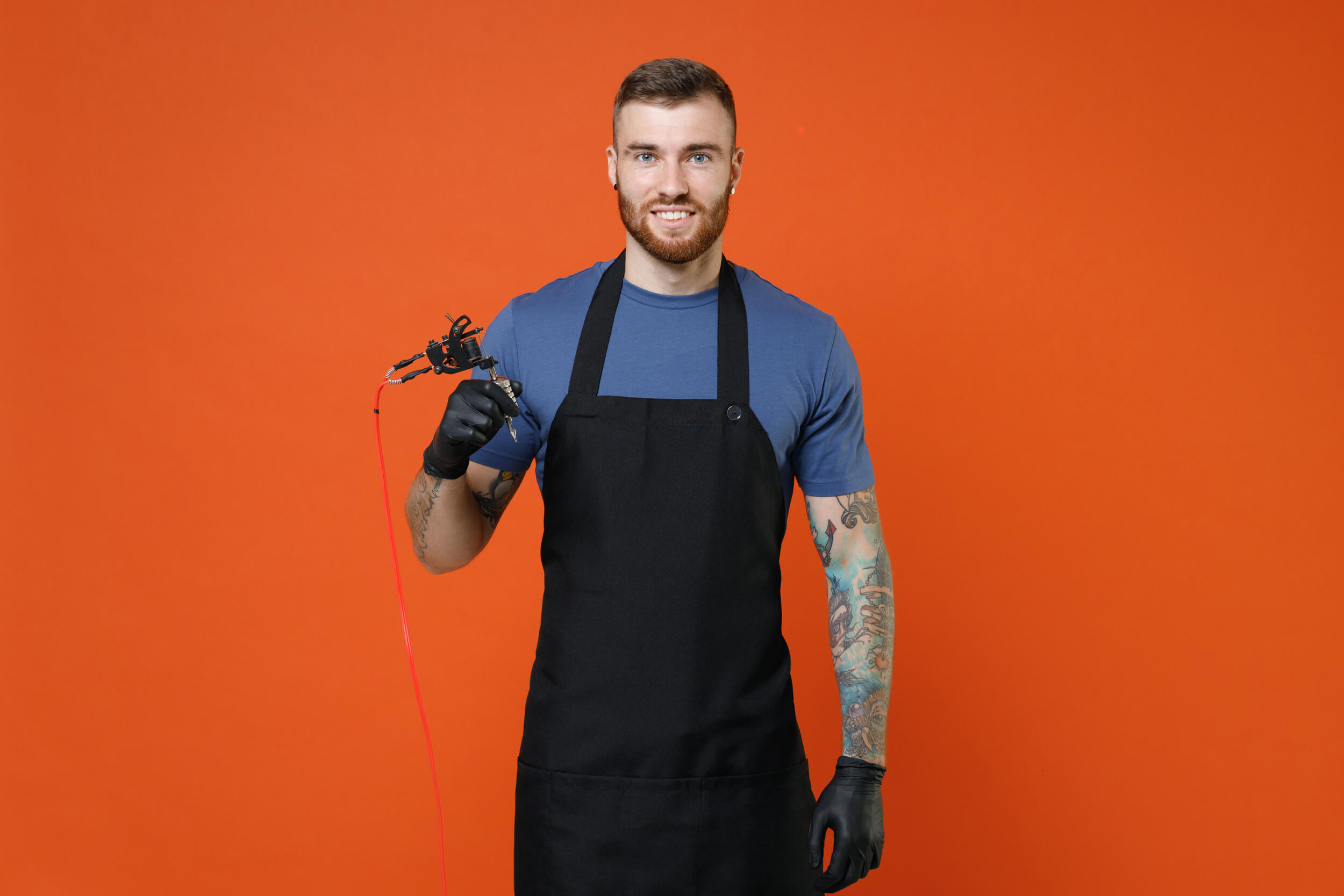 homme tatoué qui tatoue