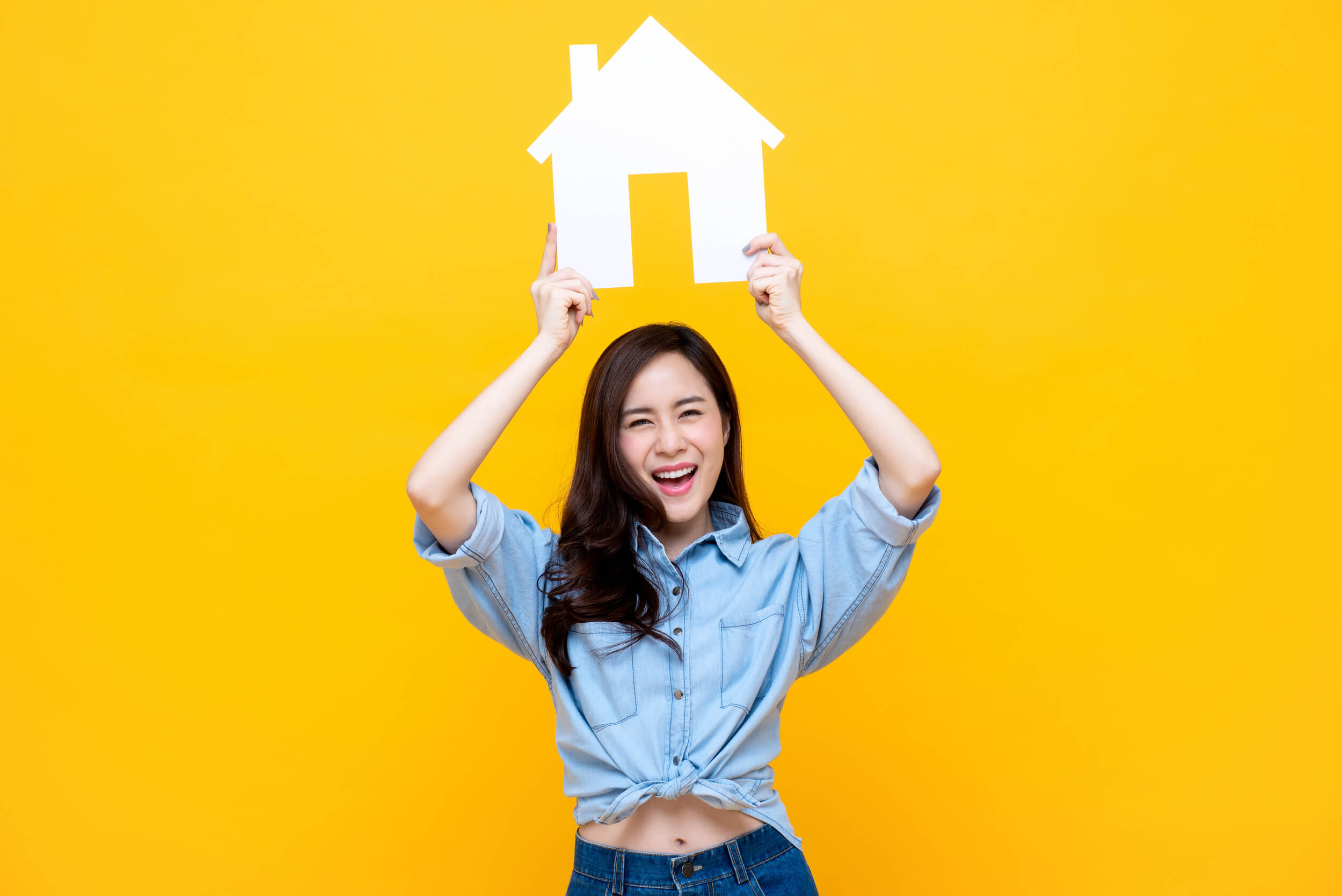 femme tenant une maison en carton sur la tête