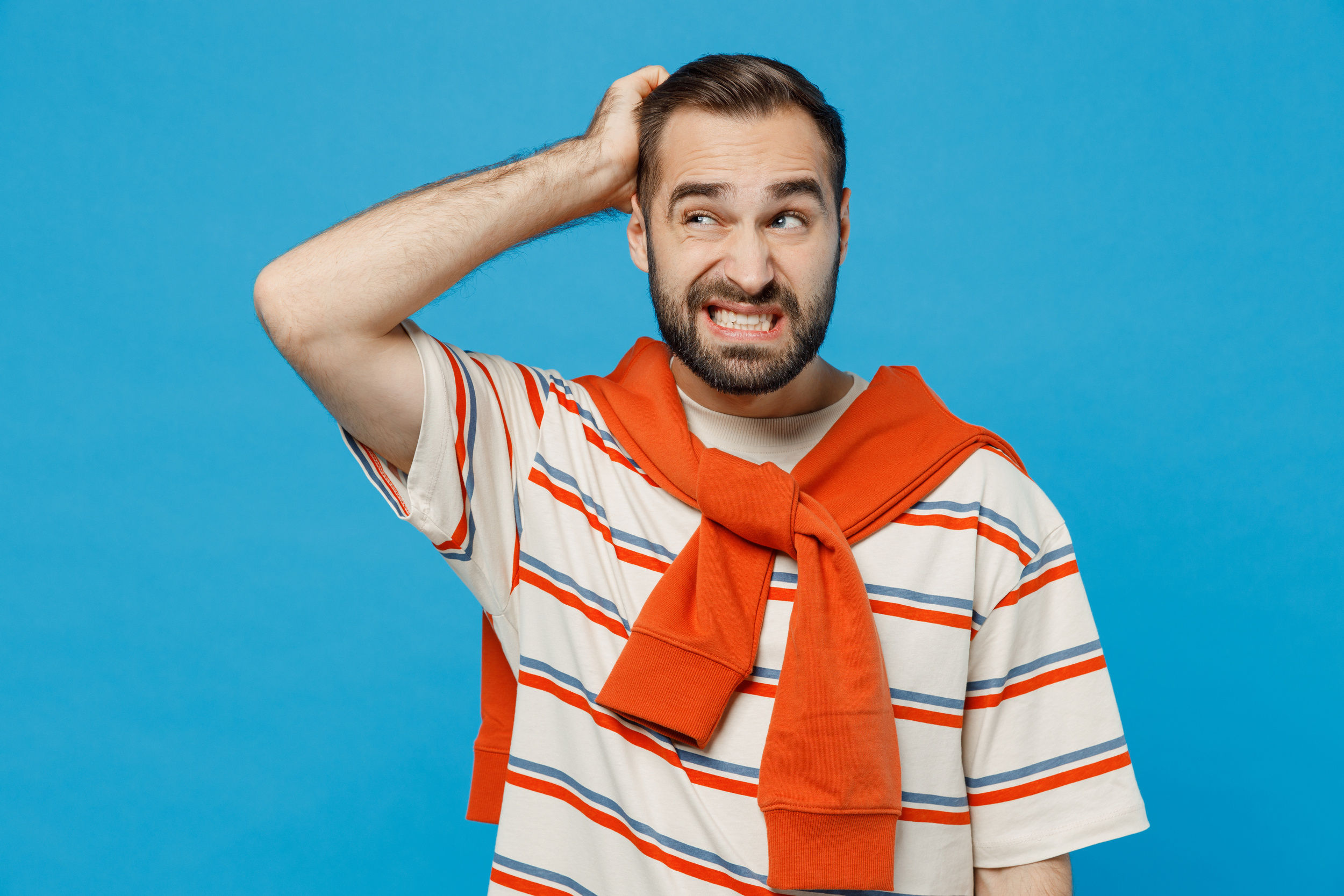 homme fait la grimace en se tenant la tête