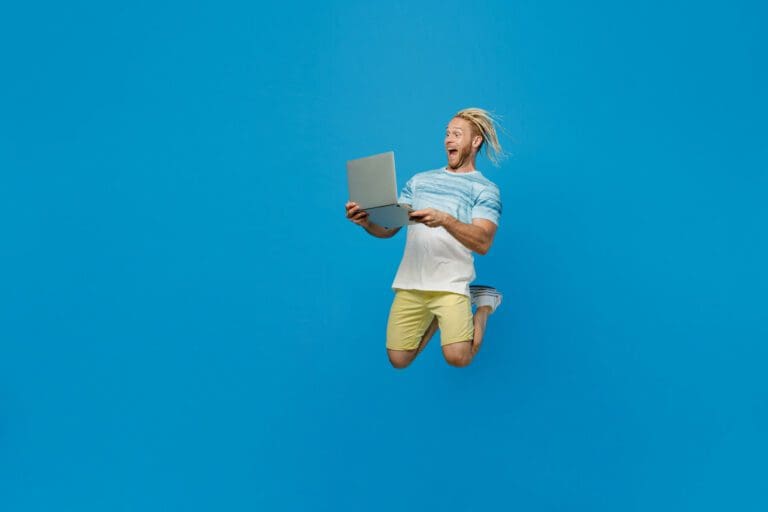 homme saute avec un ordinateur