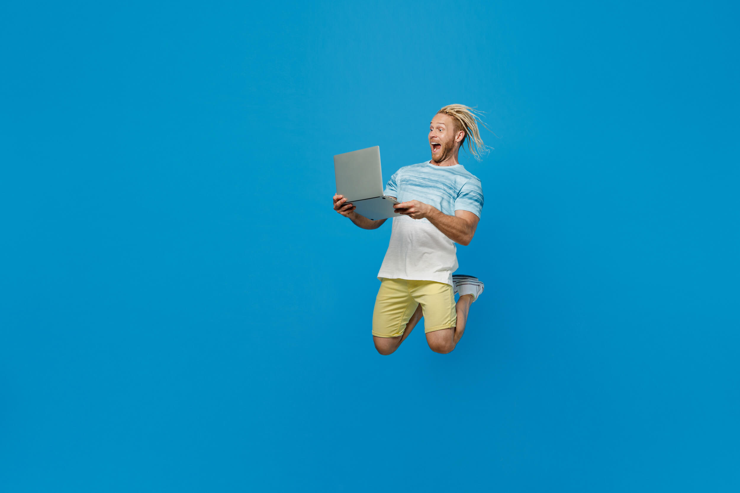 homme saute avec un ordinateur